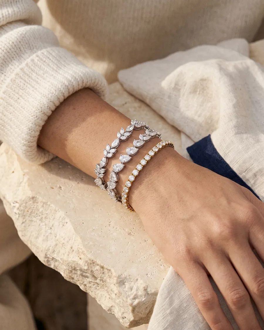 A wrist wearing three Aaryam diamond bracelets stacked together